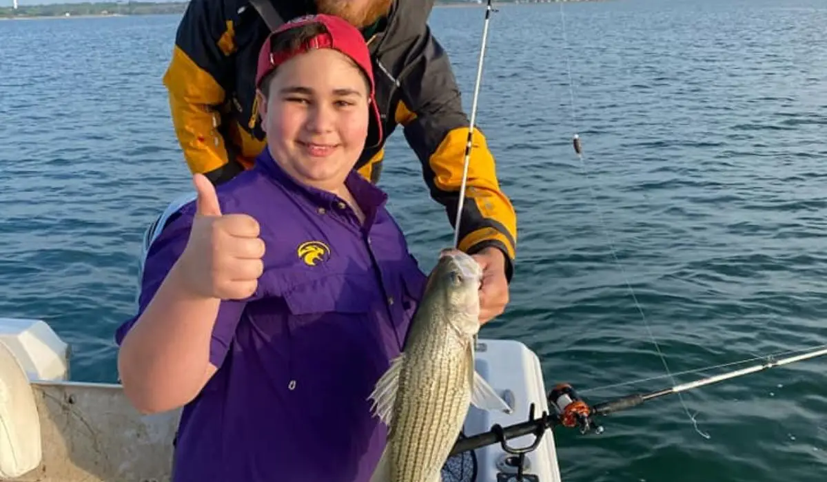 A young boy and his fishing guide caught a large fish.