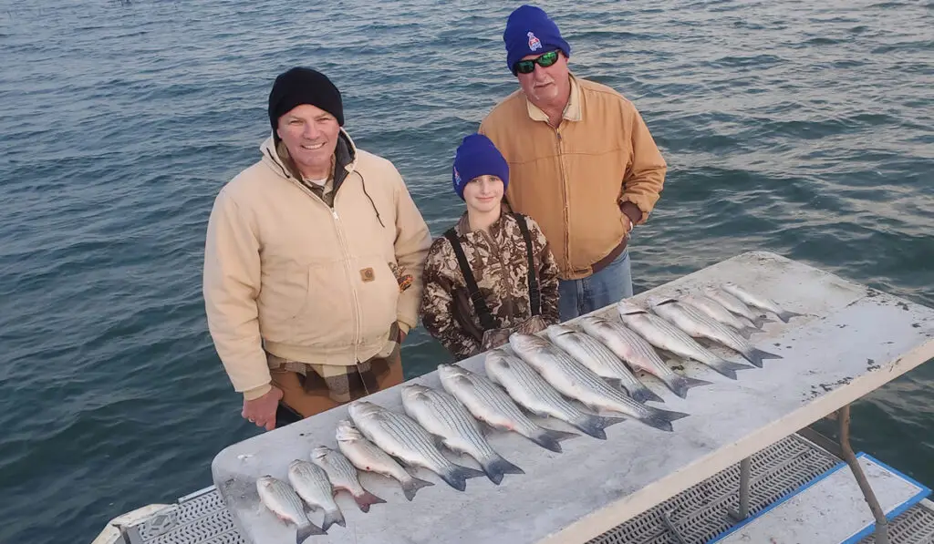 two adult men and a boy at Lake Buchanan with fish caught